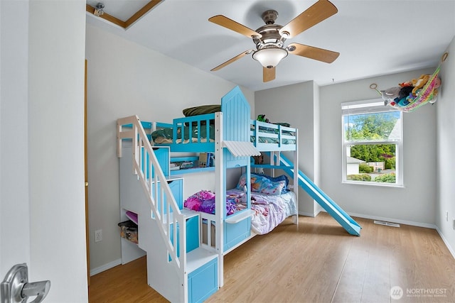bedroom featuring wood finished floors, baseboards, and ceiling fan