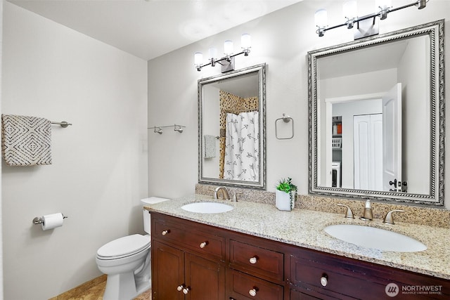 bathroom featuring toilet and double vanity