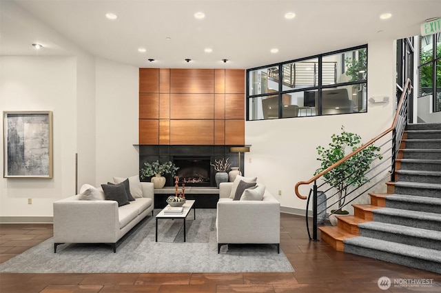 living area featuring baseboards, a fireplace, recessed lighting, and stairs