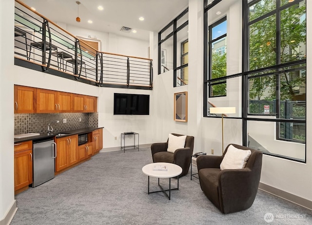 interior space with baseboards, carpet flooring, a towering ceiling, and visible vents