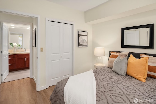 bedroom with a sink, a closet, and light wood-style flooring