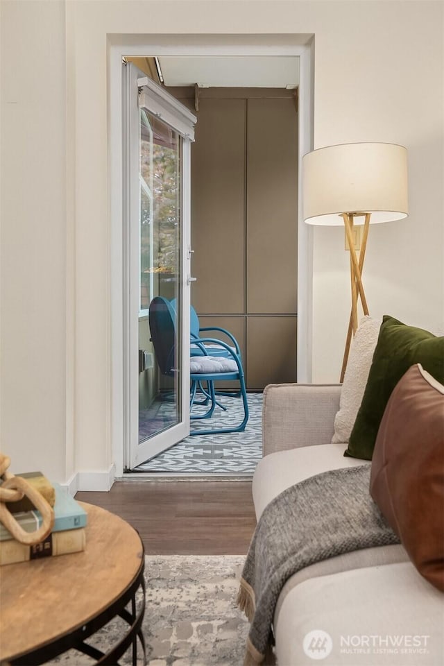sitting room with baseboards and wood finished floors