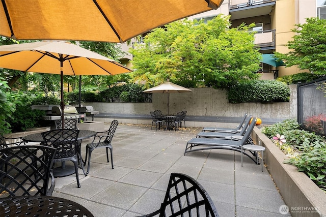 view of patio / terrace with outdoor dining area, fence, and an outdoor kitchen