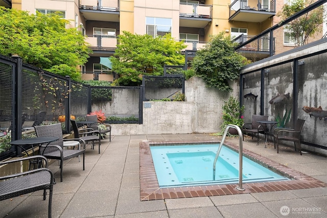 view of swimming pool with a patio, an in ground hot tub, and fence