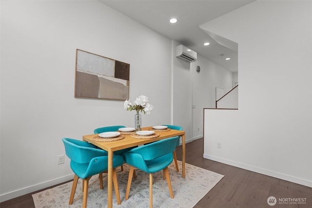 dining room with baseboards, a wall unit AC, recessed lighting, and wood finished floors