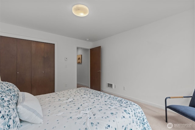 bedroom featuring a closet, baseboards, carpet flooring, and visible vents