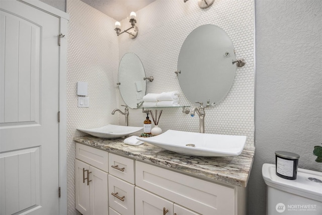 bathroom with double vanity and toilet