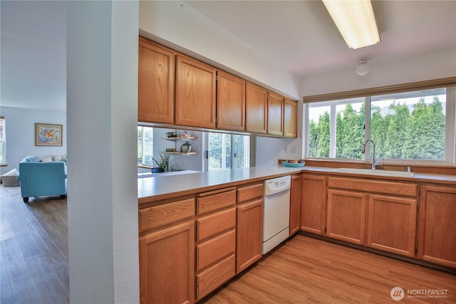 500 Creekside Ter Unit 101, Langley, WA 98260 - kitchen with white dishwasher, a sink, light countertops, and light wood finished floors