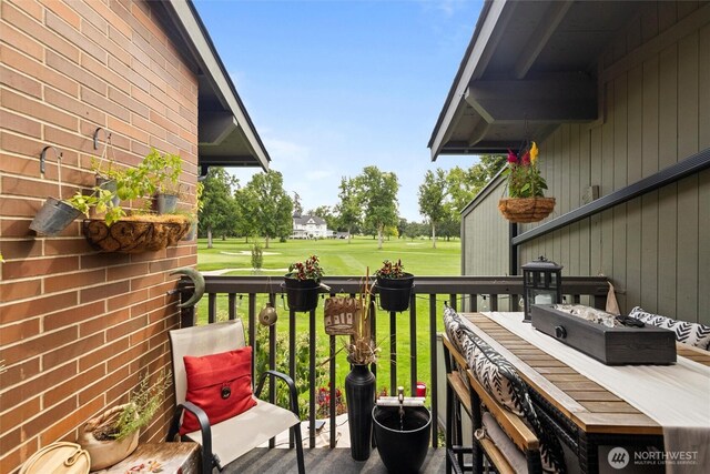 wooden terrace with a yard and view of golf course