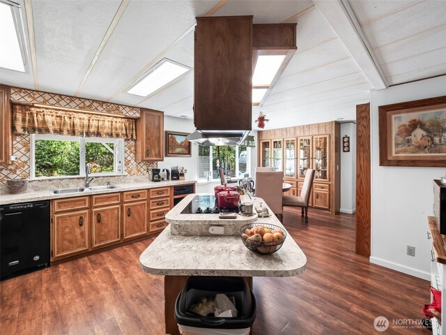 kitchen featuring brown cabinetry, a sink, light countertops, baseboards, and black appliances