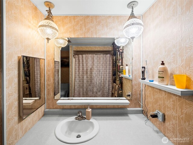 bathroom with a sink and wallpapered walls