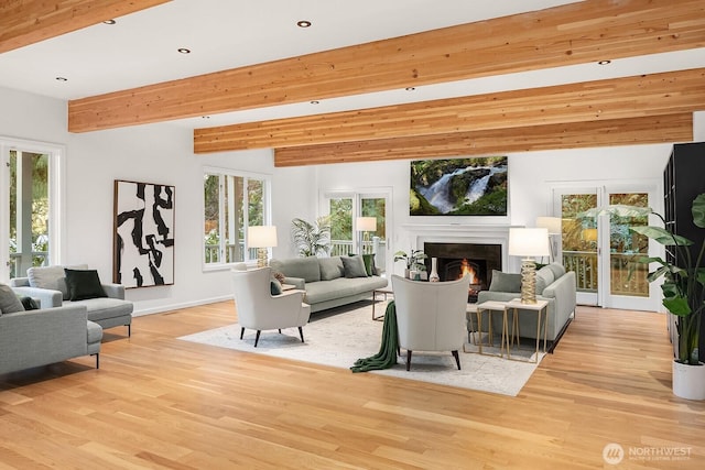 living area featuring light wood-type flooring, plenty of natural light, beamed ceiling, and recessed lighting