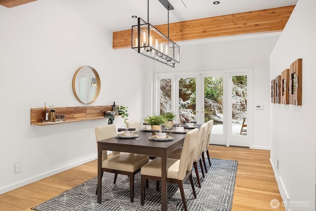 dining area with light wood-style floors, baseboards, and a chandelier