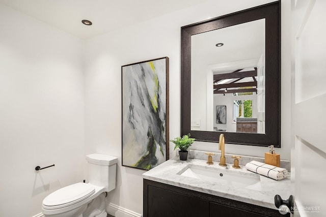 bathroom featuring recessed lighting, baseboards, vanity, and toilet