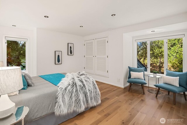 bedroom with baseboards, multiple windows, recessed lighting, and light wood-style flooring