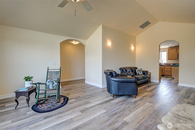 interior space featuring arched walkways, a ceiling fan, visible vents, and vaulted ceiling