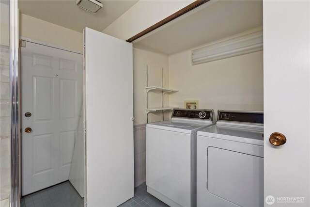 laundry area with tile patterned floors, laundry area, and washer and clothes dryer