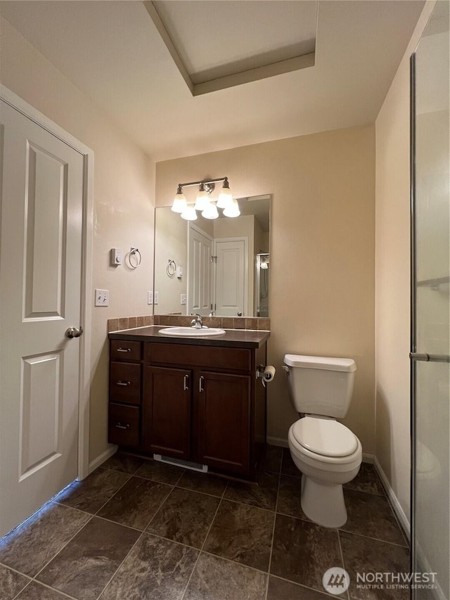 bathroom with vanity, baseboards, and toilet