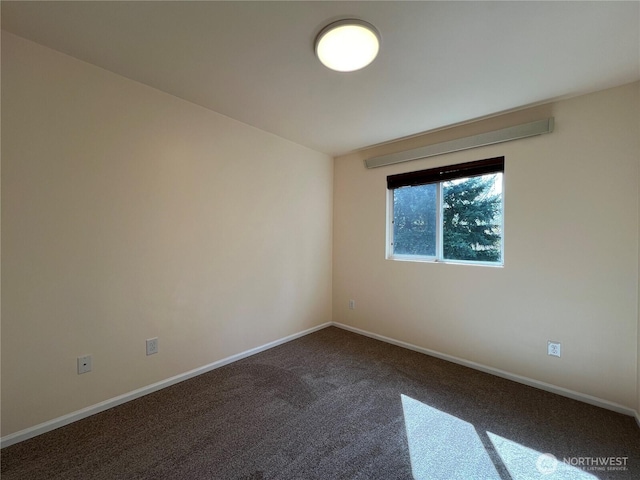 carpeted spare room with baseboards