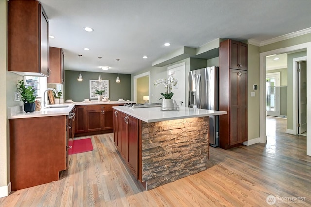 kitchen with light wood-type flooring, recessed lighting, a center island, stovetop, and stainless steel fridge with ice dispenser