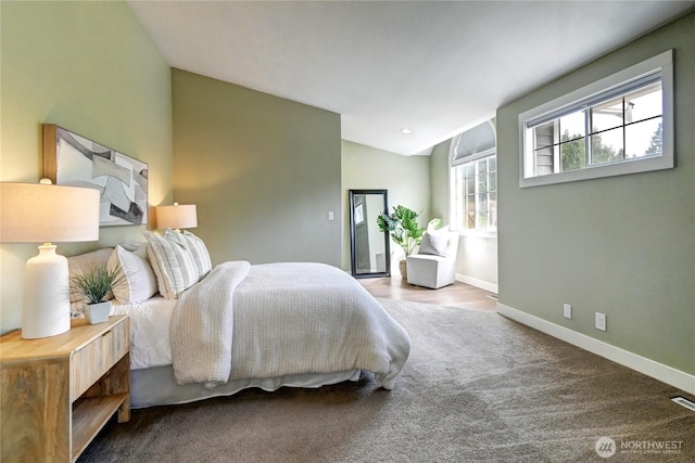 carpeted bedroom featuring baseboards and vaulted ceiling