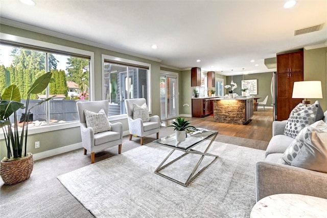 living room with baseboards, ornamental molding, recessed lighting, and visible vents