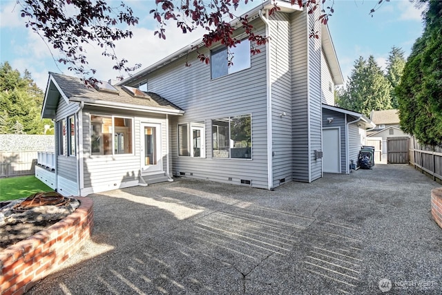 rear view of house with fence, a patio, a shed, crawl space, and entry steps