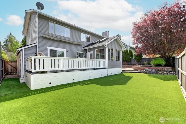 rear view of house with a sunroom, a fenced backyard, a yard, and a deck