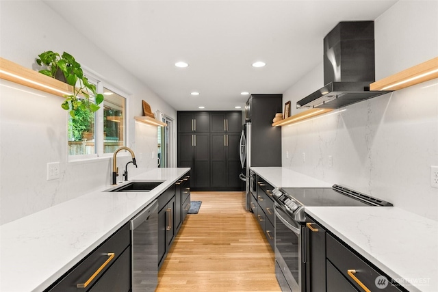 kitchen featuring open shelves, ventilation hood, dark cabinetry, a sink, and appliances with stainless steel finishes