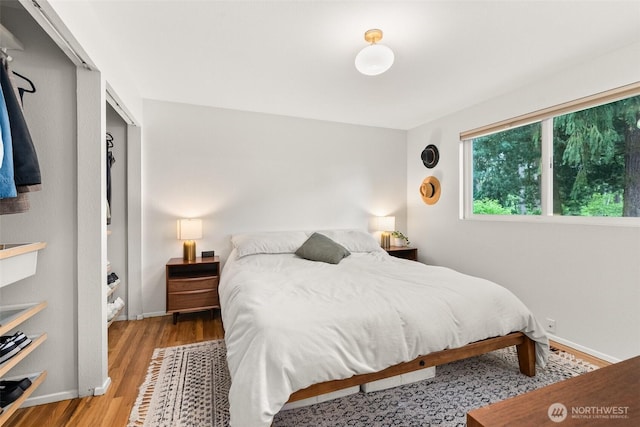 bedroom with baseboards and wood finished floors