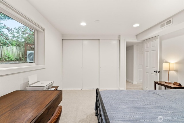 bedroom with light carpet, a closet, recessed lighting, and visible vents
