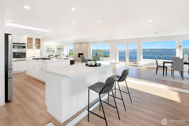 kitchen featuring a kitchen island, stainless steel appliances, recessed lighting, and light wood-style flooring