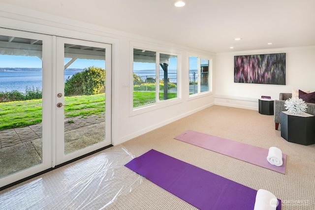 exercise area with recessed lighting, carpet flooring, and a water view
