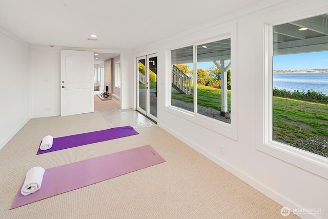 exercise area with a water view, baseboards, recessed lighting, and carpet