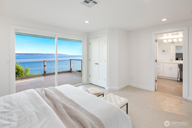 bedroom featuring access to exterior, light colored carpet, visible vents, baseboards, and a water view