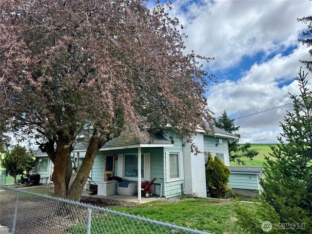 view of front of house with covered porch, fence private yard, and a front yard