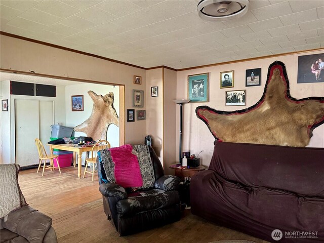 living area with crown molding and wood finished floors