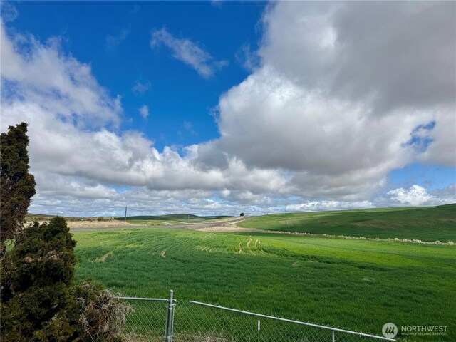 exterior space with fence and a rural view