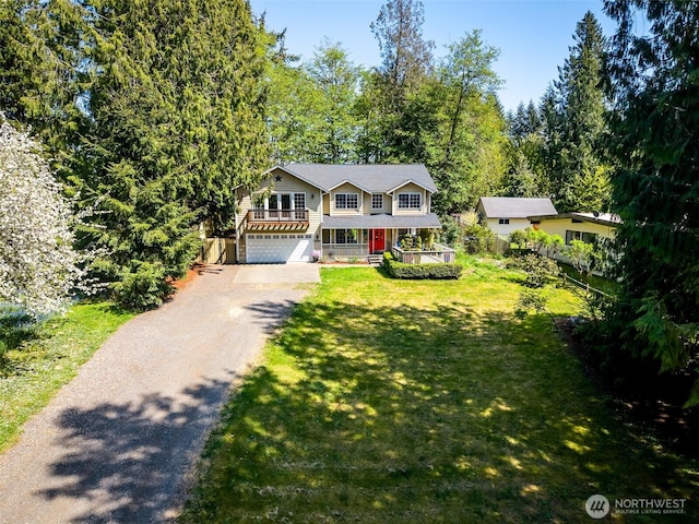 view of front of home with covered porch, an attached garage, driveway, and a front lawn