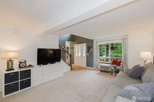 living area featuring stairway, baseboards, and light carpet