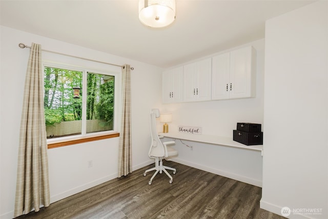 office space with baseboards, dark wood finished floors, and built in desk