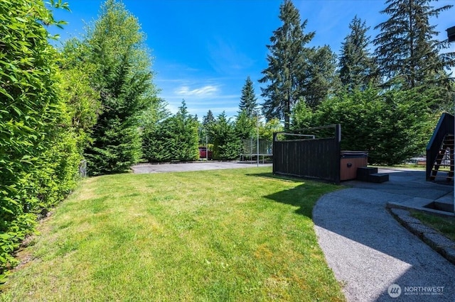3507 222nd St SW, Mountlake Terrace, WA 98043 - view of grassy yard with a trampoline, a hot tub, and a patio area