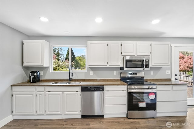 245 Stowell Rd, Salkum, WA 98570 - kitchen with stainless steel appliances, dark countertops, white cabinetry, and a sink