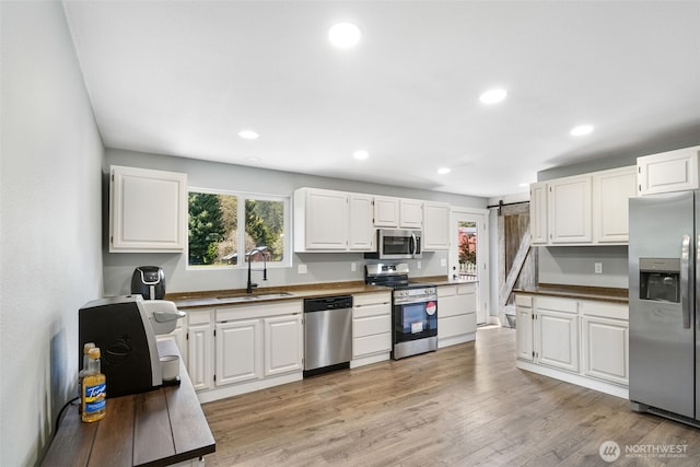245 Stowell Rd, Salkum, WA 98570 - kitchen with a sink, appliances with stainless steel finishes, white cabinets, and a barn door