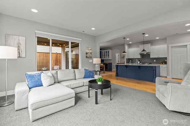 living area with recessed lighting, arched walkways, and light carpet