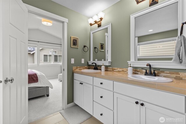 full bath with a sink, tile patterned flooring, ensuite bathroom, and double vanity
