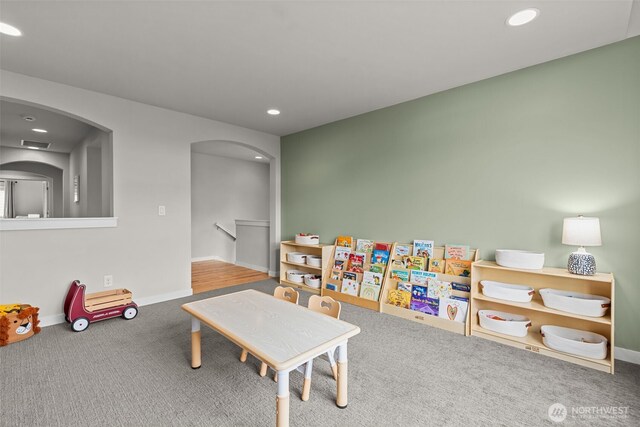 rec room featuring recessed lighting, baseboards, arched walkways, and carpet