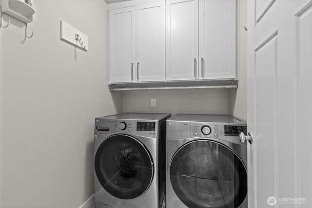 clothes washing area with baseboards, cabinet space, and independent washer and dryer