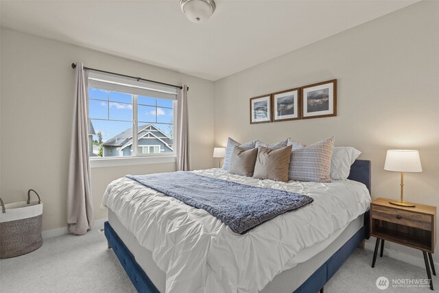 bedroom with baseboards and light carpet