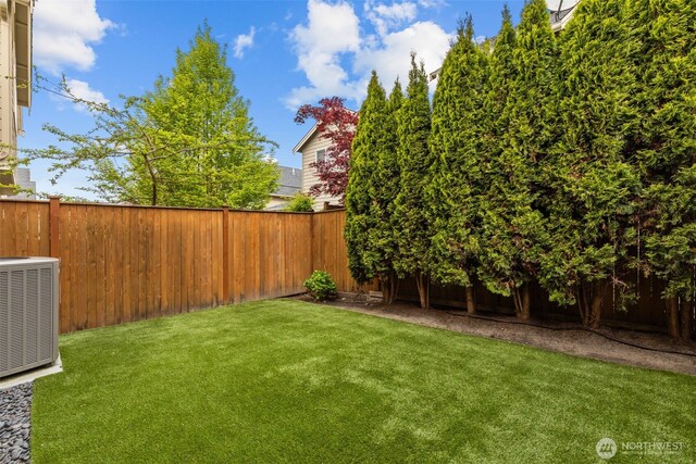 view of yard featuring a fenced backyard and central air condition unit